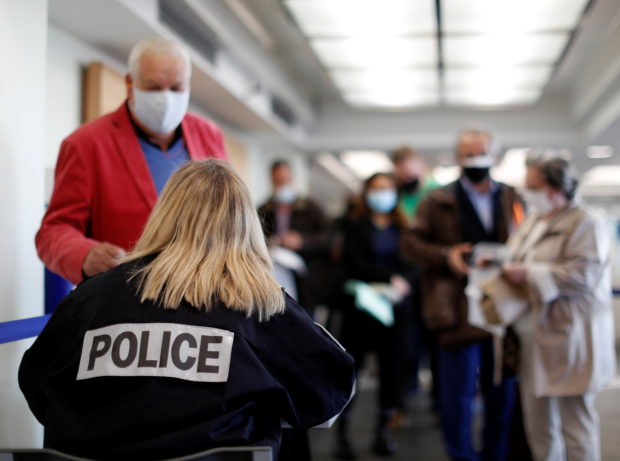 A French border police officer controls passengers as they arrive at Nice Cote d'Azur Airport amid the coronavirus disease (COVID-19) outbreak in Nice, France, March 1, 2021; Nice Cote d'Azur International Airport amid the coronavirus disease (COVID-19) outbreak