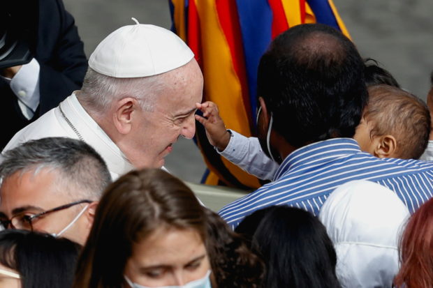 Pope Francis reacts as a child greets him upon his arrival for the weekly general audience at the San Damaso courtyard, amid the coronavirus disease (COVID-19) pandemic, at the Vatican, June 2, 2021.