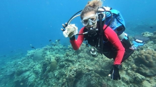 Resort owner and dive instructor Carmela Sevilla shows a plastic trash she recovered underwater during a scuba diving activity in Bauan, Batangas, Philippines, June 6, 2021. Picture taken June 6, 2021. REUTERS/Peter Blaza
