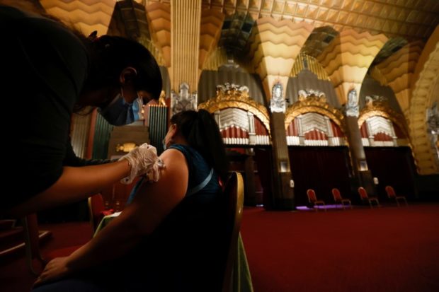 A person receives a shot of the Pfizer-BioNTech coronavirus disease (COVID-19) vaccine with a chance to win a pair of tickets to see "Hamilton" at a pop-up vaccination clinic at Pantages theatre in Los Angeles, California, U.S., June 12, 2021. REUTERS/Mario Anzuoni