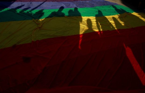Participants' shadows are seen on a rainbow flag during a march in support of gay marriage, sexual and gender diversity in Ciudad Juarez