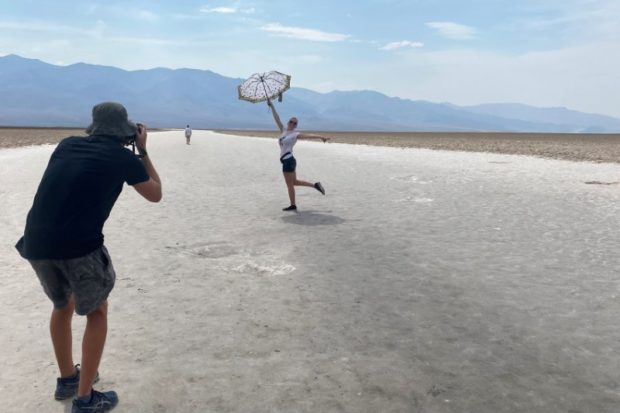 43-year-old Lana, a tourist from North Carolina poses for a picture holding an umbrella at Badwater Basin, the lowest point of North America below sea level in Death Valley, California, U.S. June 16, 2021. Picture taken June 16, 2021.  REUTERS/Norma Galeana