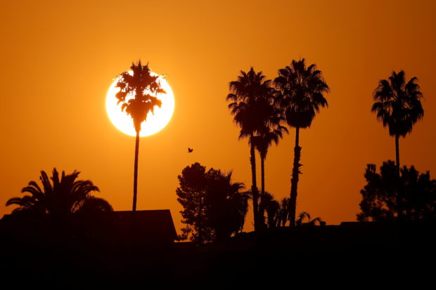 The morning sun rises over a neighborhood as a heatwave continues during the outbreak of the coronavirus disease (COVID-19) in Encinitas, California, U.S., August 19, 2020. REUTERS/Mike Blake/File Photo