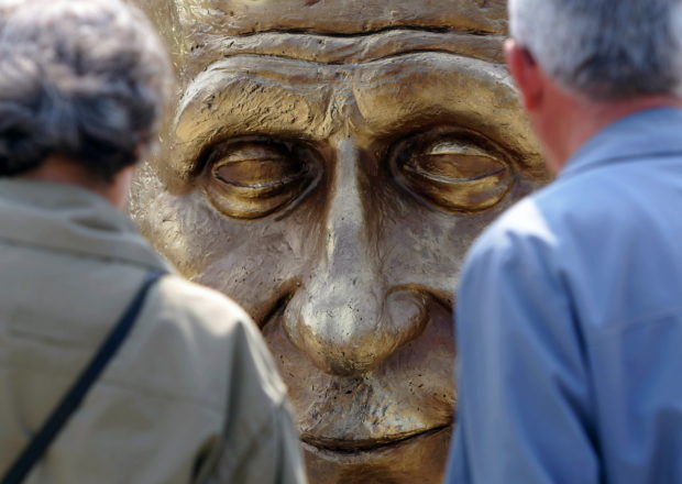 Elderly Romanians look at a sculpture of France's former Foreign Minister Robert Schuman at a park in Bucharest, Romania on Europe Day, May 9, 2006 after the unveiling ceremony of a monument dedicated to key personalities involved in the creation of the European Union.  REUTERS/Bogdan Cristel/File Photo
