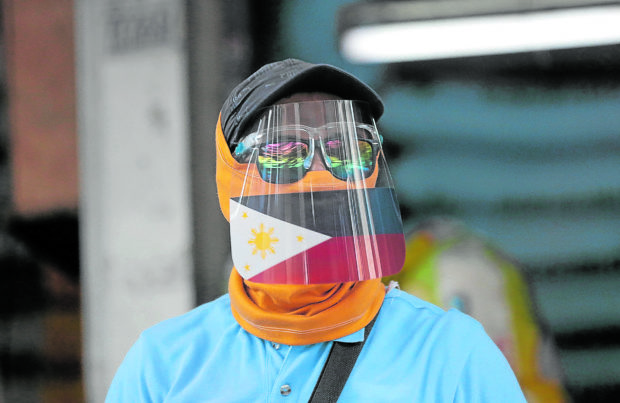A traffic enforcer wears a face shield on top of his face mask