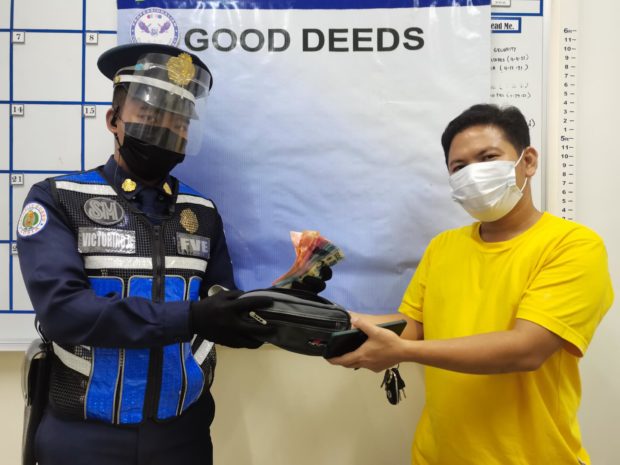 SM Center Pulilan security personnel Rodel Victorino returns the cash to its owner Cristan Parajas