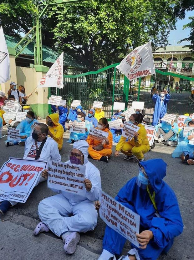 Members of the Alliance of Health Workers hold a sit down protest in front of the Department of Health office in Manila