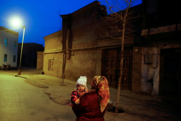 uighur woman carrying a child