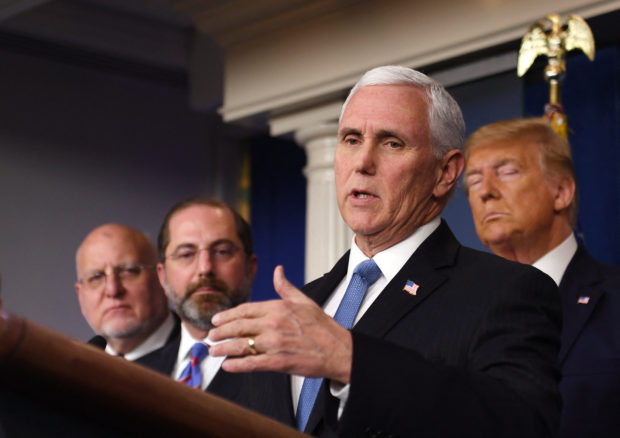 US President Donald Trump (R) stands behind US Vice President Mike Pence as he speaks at a news conference with members of the Centers for Disease Control and Prevention(CDC) on the COVID-19 outbreak at the White House on February 26, 2020. - Trump appointing Vice President Mike Pence to lead the US response to the novel coronavirus. "I'm going to be announcing exactly right now that I'm going to be putting our vice president Mike Pence in charge," Trump said. "Mike will be working with the professionals and doctors and everybody else that's working on the team." (Photo by Eric BARADAT / AFP)