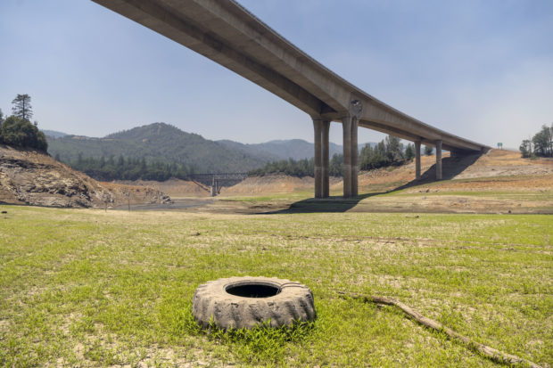 A tire usually used as a mooring sits on dry land along the lakebed of Shasta Lake in Lakehead, California on July 2, 2021, as the Salt fire burns nearby. - Firefighters are battling nearly a dozen wildfires in the region following a heatwave and multiple lightning strikes. 