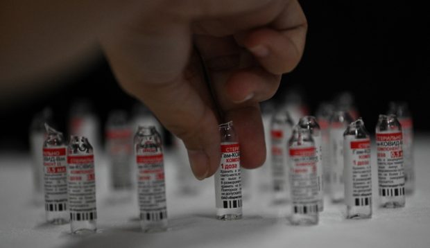 A health worker prepares Gamaleya National Center of Epidemiology and Microbiology's Sputnik V COVID-19 vaccines during a vaccination for residents in Mandaluyong City, suburban Manila on July 15, 2021. (Photo by Ted ALJIBE / AFP)