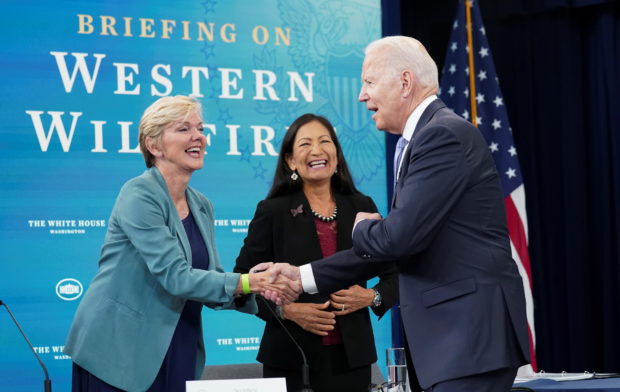U.S. President Joe Biden shakes hands with Energy Secretary Jennifer Granholm next to Interior Secretary Deb Haaland as he arrives for a meeting with cabinet officials, governors, and private sector partners to discuss preparedness of Western states to heat, drought and wildfires this season, at the White House in Washington, U.S. June 30, 2021. REUTERS/Kevin Lamarque
