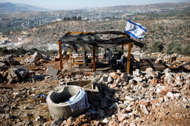 Jewish settlers sit together in Givat Eviatar, a new Israeli settler outpost, near the Palestinian village of Beita in the Israeli-occupied West Bank June 23, 2021. Picture taken June 23, 2021. REUTERS/Amir Cohen