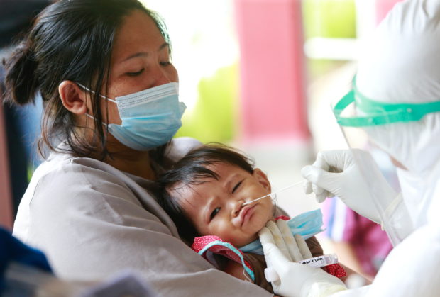 Fawziah, a 1-year-old infant, reacts as a healthcare worker takes a swab sample to test for the coronavirus disease (COVID-19) during mass testing at a school in Jakarta