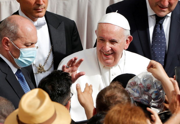 Pope Francis greets people, as he arrives at the San Damaso courtyard for the weekly general audience, amid the coronavirus disease (COVID-19) pandemic, at the Vatican, June 23, 2021. 