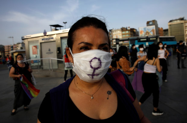 A woman wears a protective face mask as demonstrators keep social distance by holding onto purple ribbons as they protest for women rights and against child abuse, amid the spread of the coronavirus disease (COVID-19), in Istanbul, Turkey, May 20, 2020