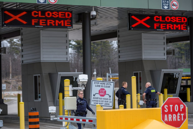 Canadian Border Services Agency officers stand in front of two closed Canadian border checkpoints after it was announced that the border would close to "non-essential traffic"  to combat the spread of novel coronavirus disease (COVID-19) at the U.S.-Canada border crossing at the Thousand Islands Bridge in Lansdowne, Ontario, Canada March 19, 2020.  REUTERS/Alex Filipe