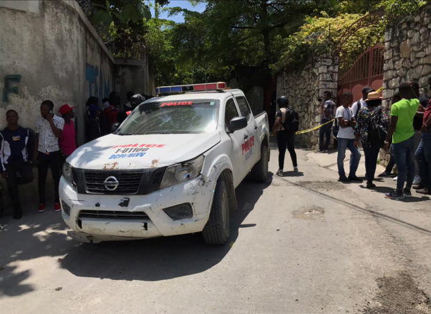 People stand next to a police car and a yellow police cordon near the residence of Haiti's President Jovenel Moise after he was shot dead by unidentified attackers, in Port-au-Prince, Haiti July 7, 2021. REUTERS/Estailove St-Val