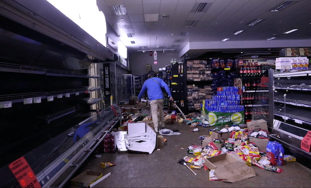 Self-armed locals look for looters inside a supermarket in Durban