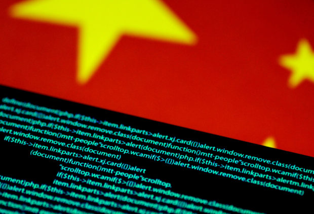 Computer code is seen on a screen above a Chinese flag in this July 12, 2017 illustration photo. REUTERS/Thomas White/Illustration/File Photo