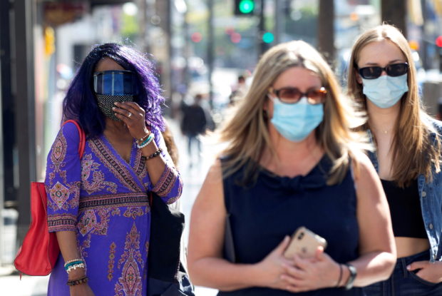 People wearing face protective masks walk on Hollywood Blvd during the outbreak of the coronavirus disease (COVID-19), in Los Angeles, California, U.S., March 29, 2021. REUTERS/Mario Anzuoni/File Photo/File Photo