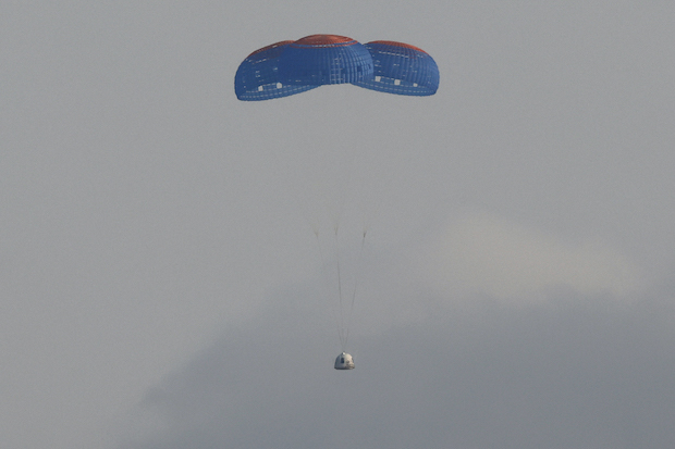 The capsule carrying billionaire businessman Jeff Bezos and three crew members returns by parachute after their flight aboard Blue Origin's New Shepard rocket near Van Horn