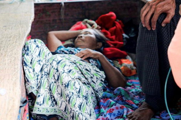 Relative sits with a coronavirus disease (COVID-19) patient in the town of Kale, Sagaing Region, Myanmar