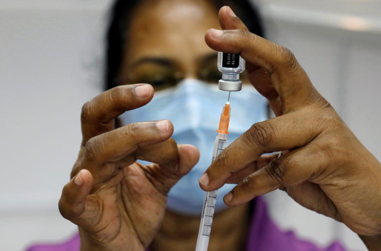 A medical worker prepares a syringe at a coronavirus disease (COVID-19) vaccination center in Singapore
