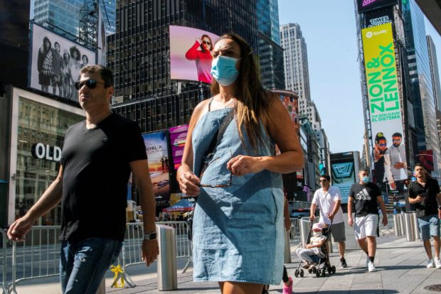 People wear masks around Times Square, as cases of the infectious coronavirus Delta variant continue to rise in New York City, New York, U.S., July 23, 2021.
