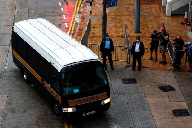 A prison van arrives as police stand guard for Tong Ying-kit's arrival, the first person charged under a new national security law, in Hong Kong