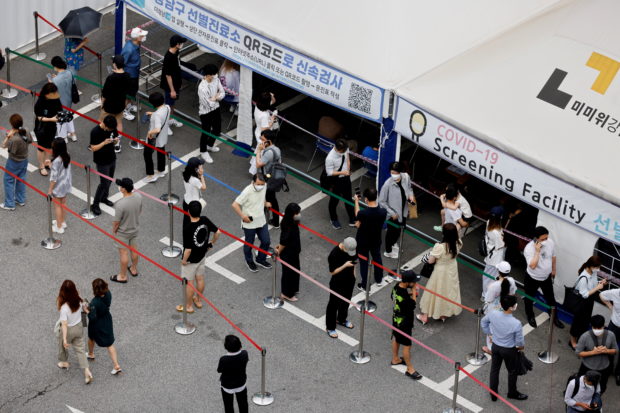 People wait in line for a coronavirus disease (COVID-19) test at a testing site which is temporarily set up at a public health center in Seoul, South Korea, July 9, 2021. 