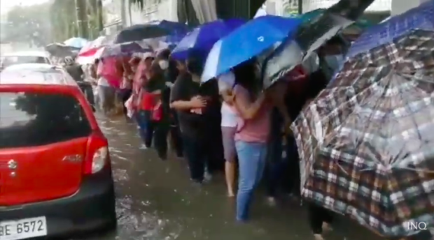 Manila residents brave heavy rains and floods to get their vaccine jabs at the San Andres Sports Complex. Screengrab from Radyo Inquirer
