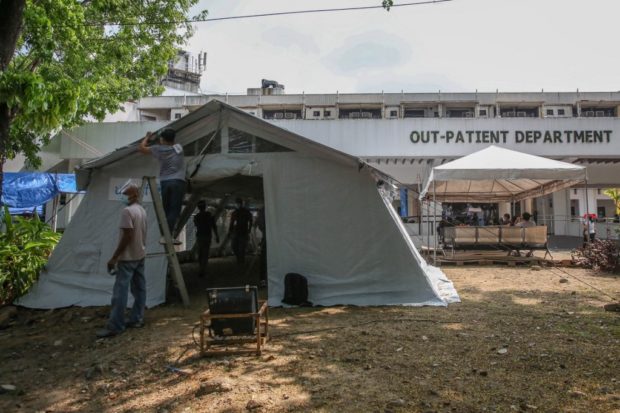 This photo taken on April 6, 2021 shows a makeshift ward (L) built for COVID-19 patients at a hospital in Manila. - More contagious variants of the coronavirus have been blamed for a record surge in infections in Metro Manila that has overwhelmed hospitals and sent the national capital region into lockdown. (Photo by Jam STA ROSA / AFP) / TO GO WITH Health-virus-Philippines,FOCUS by Allison Jackson and Cecil Morella