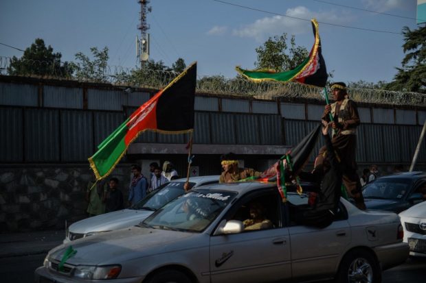 People carry Afghanistan's national flag to mark the 102nd Independence Day of Afghanistan in the Wazi Akbar khan area of Kabul on August 19, 2021, days after the Taliban's military takeover of the country. (Photo by Hoshang Hashimi / AFP)