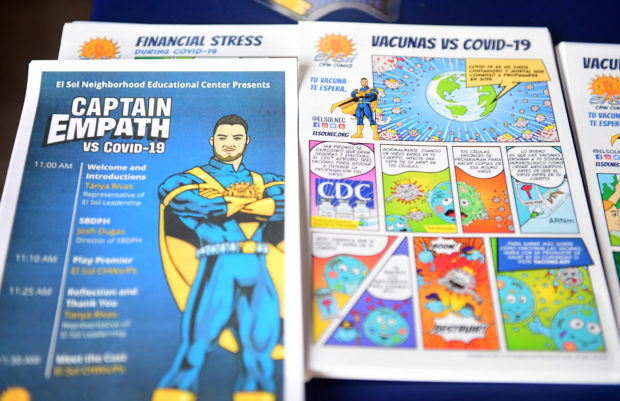 A Superhero style ad is displayed with Covid-19 comics at the El Sol Neighborhood Education Center for arrivals to a Covid-19 superhero themed play on August 19, 2021 in San Bernardino, California. - Is it a bird? Is it a plane? No, it's Captain Empathy, here to vanquish misinformation about vaccines in a Hollywood-style twist on the fight against Covid-19. With equal measures of "ker-pow!" and kitsch, the caped crusader battles the evil villain Coronavirus, with medical science as his superpower. Captain Empathy, who cuts a heroic dash in blue and yellow, disarms his nemesis by convincing two young people to get immunized, in a piece of educational theatre in San Bernadino, near Los Angeles. 