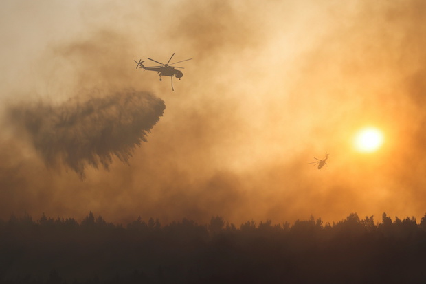 Helicopters flying over a wildfire in Greece