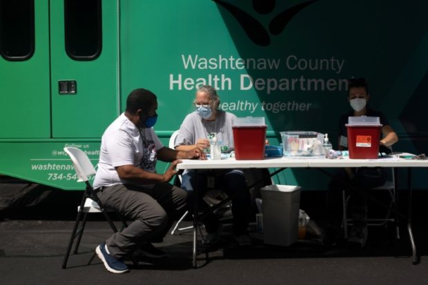 Jane Nickert, director of nursing for the Washtenaw County Health Department converses with a person getting ready to receive their COVID-19 vaccine during an event hosted by Southeast Michigan Pull Over Prevention at Grace Fellowship Church in Ypsilanti, Michigan, U.S.,