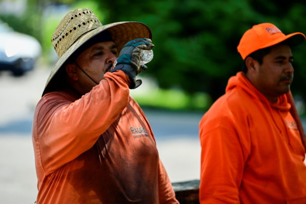 Aureliano Dominguez drinks water after finishing a landscaping job as a heat wave continues in Portland, Oregon, U.S., August 12, 2021. REUTERS/Mathieu Lewis-Rolland