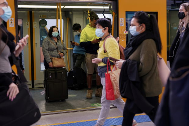 Commuters wear protective face masks on public transit at Central Station following the implementation of new public health regulations from the state of New South Wales, as the city grapples with an outbreak of the coronavirus disease (COVID-19) in Sydney, Australia, June 23, 2021. REUTERS/Loren Elliott/File Photo