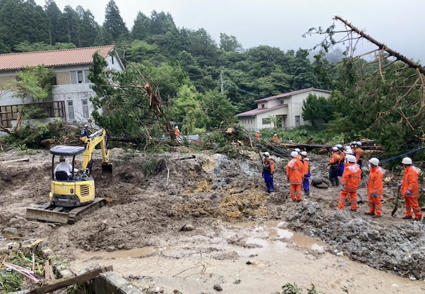 Rescue workers search for missing people at a landslide site caused by heavy rainfall in Unzen