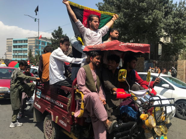 People carry the national flag at a protest held during the Afghan Independence Day in Kabul, Afghanistan August 19, 2021. REUTERS/Stringer