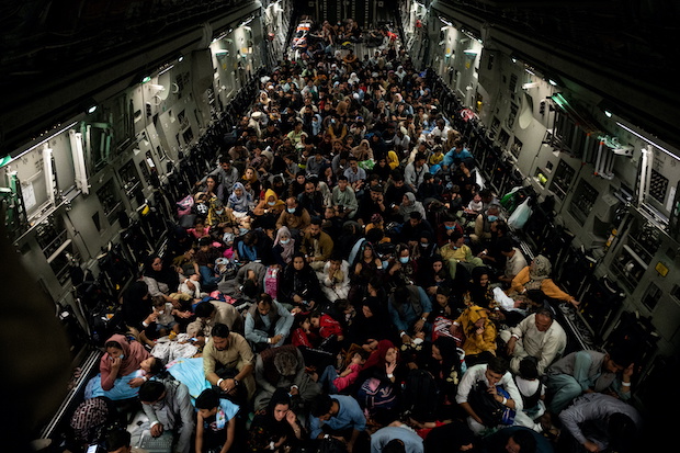 Evacuees from Afghanistan sit inside a military aircraft during an evacuation from Kabul