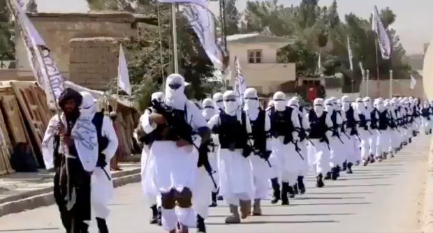 Taliban fighters march in uniforms on the street in Qalat, Zabul Province, Afghanistan, in this still image taken from social media video uploaded August 19, 2021 and obtained by REUTERS