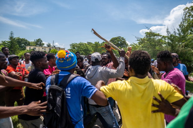 Followers of former Haitian President Michel Martelly fight over an envelope with a cash donation from a Martelly bodyguard during his departure outside the OFATMA hospital after Merely left, in Les Cayes, Haiti August 20, 2021. REUTERS/Ricardo Arduengo
