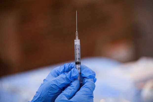 FILE PHOTO: A syringe is filled with a dose of Pfizer's COVID-19 vaccine at a pop-up community vaccination center at the Gateway World Christian Center in Valley Stream, New York, U.S., February 23, 2021. REUTERS/Brendan McDermid/File Photo