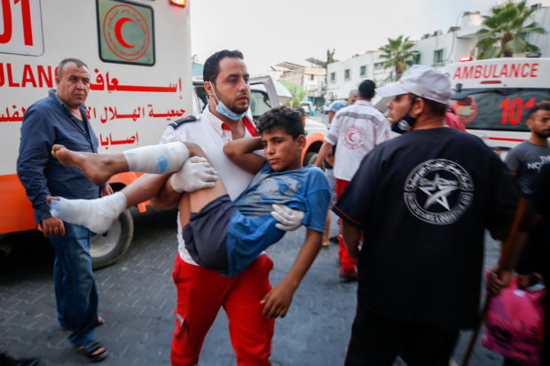 A wounded Palestinian is carried after taking part in a protest at Israel-Gaza border east of Gaza City, August 21, 2021. REUTERS/Mohammed Salem