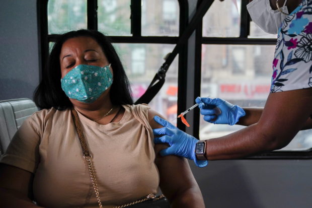 A person receives a dose of the Pfizer-BioNTech vaccine for the coronavirus disease (COVID-19), at a mobile inoculation site in the Bronx borough of New York City, New York, U.S., August 18, 2021.  REUTERS/David 'Dee' Delgado