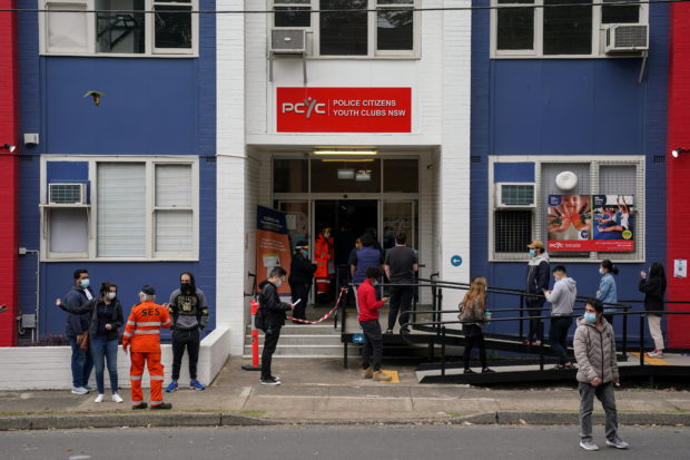 People wait in line outside a coronavirus disease (COVID-19) vaccination clinic in the Bankstown suburb during a lockdown to curb an outbreak of cases in Sydney, Australia, August 25, 2021. REUTERS/Loren Elliott