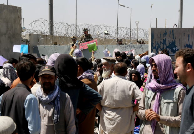 Crowds of people show their documents to U.S. troops outside the airport in Kabul, Afghanistan August 26, 2021. REUTERS/Stringer