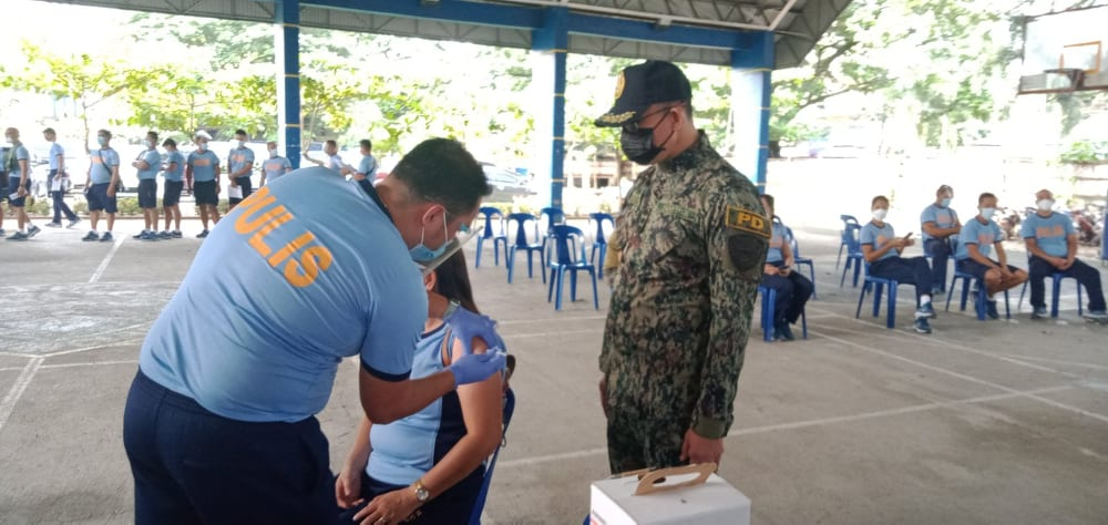 A police officer is vaccinated against COVID-19 at Camp Julian Olivas in Pampanga province